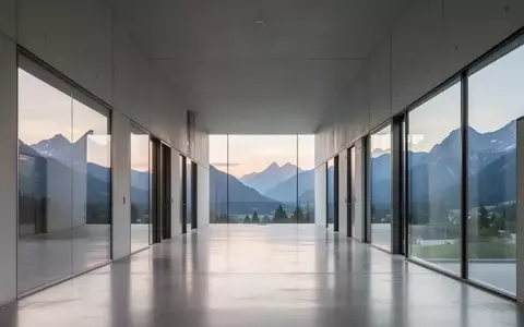 Ein minimalistischer, moderner Forschungsflur mit Blick auf eine österreichische Berglandschaft bei Tagesanbruch. - Foto: über boerse-global.de