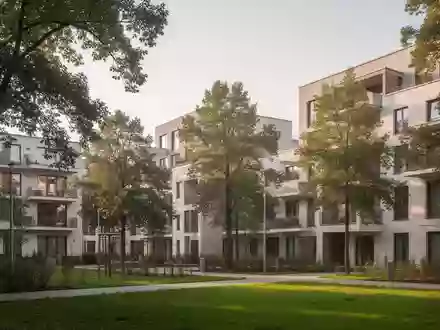 Moderne Wohngebäude in einer grünen Wohnsiedlung in München bei natürlichem Tageslicht. - Foto: über boerse-global.de