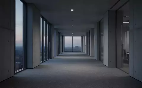 Ein leerer, minimalistischer Büroflur in kühlem Dämmerlicht, der Stille und architektonische Weite vermittelt. - Foto: über boerse-global.de