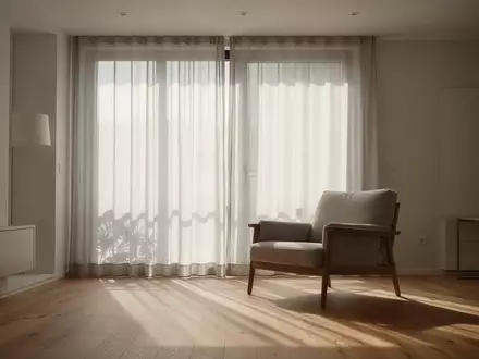 Ein helles, minimalistisch eingerichtetes Wohnzimmer mit bodentiefen Fenstern und sanftem Tageslicht, das eine ruhige Atmosphäre ausstrahlt. - Foto: über boerse-global.de