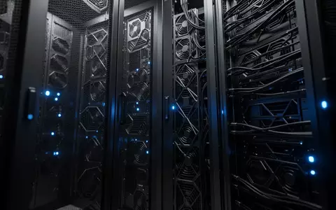 Dunkler Serverraum mit metallischen Hardware-Racks und dezenten blauen LED-Lichtern in einer industriellen Umgebung. - Foto: über boerse-global.de