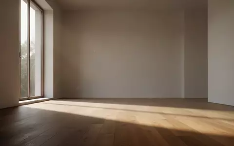 Ein minimalistischer, leerer Raum mit einfallendem Tageslicht und langen Schatten auf einem Holzboden. - Foto: über boerse-global.de