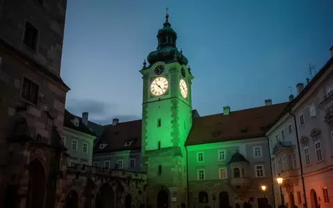 Der in grünes Licht getauchte Grazer Uhrturm bei Dämmerung als Symbol für psychische Gesundheit. - Foto: über boerse-global.de