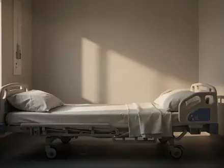 Ein minimalistisches, ruhiges Patientenzimmer mit sanftem Tageslicht, das auf ein leeres, ordentlich gemachtes Bett fällt. - Foto: über boerse-global.de