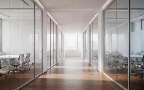 Ein minimalistisch gestalteter, moderner Büroflur mit Glaswänden und hellem Tageslicht in einer strukturierten Arbeitsumgebung. - Foto: über boerse-global.de