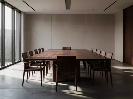 Ein minimalistischer, leerer Konferenzraum mit einem großen Holztisch und natürlichem Lichteinfall. - Foto: über boerse-global.de