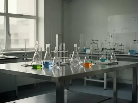 Ein minimalistisches, helles Labor mit Edelstahltisch und wissenschaftlichen Glasgeräten bei natürlichem Tageslicht. - Foto: über boerse-global.de