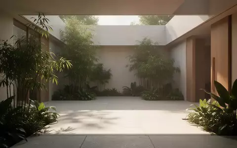 Ein sonnendurchfluteter Innenhof mit minimalistischer Architektur und Pflanzen, der eine ruhige und ausgeglichene Atmosphäre ausstrahlt. - Foto: über boerse-global.de