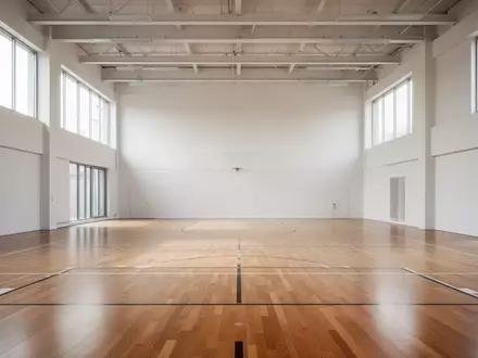 Leere, helle Sporthalle mit Parkettboden und natürlichem Lichteinfall. - Foto: über boerse-global.de