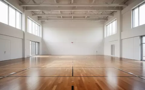 Leere, helle Sporthalle mit Parkettboden und natürlichem Lichteinfall. - Foto: über boerse-global.de