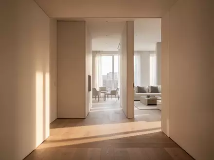 Ein heller, minimalistischer Flur in einer modernen Wohnung mit Tageslicht und klaren architektonischen Linien. - Foto: über boerse-global.de