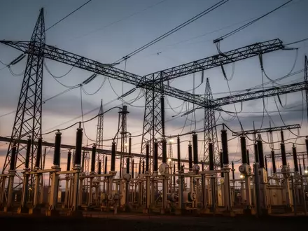 Ein Hochspannungsumspannwerk mit stählernen Gittermasten vor einem dämmrigen Abendhimmel. - Foto: über boerse-global.de