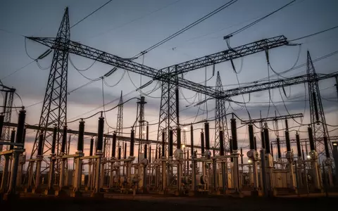 Ein Hochspannungsumspannwerk mit stählernen Gittermasten vor einem dämmrigen Abendhimmel. - Foto: über boerse-global.de
