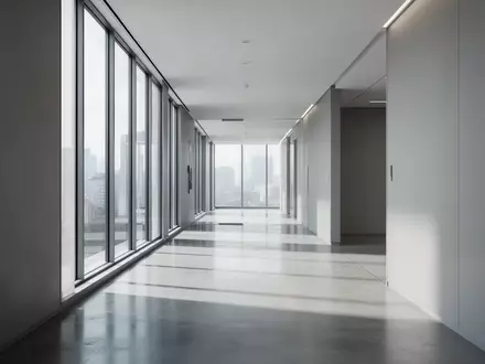Ein minimalistischer, moderner Büroflur mit poliertem Betonboden und hellem Tageslicht, das durch hohe Fenster fällt. - Foto: über boerse-global.de