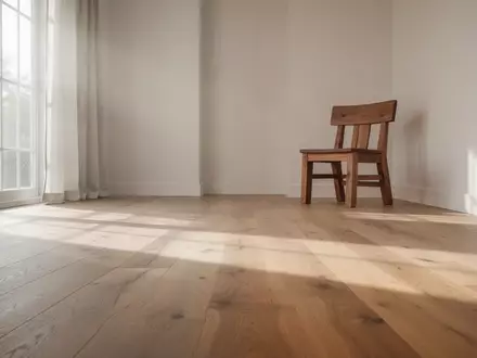 Ein heller, minimalistischer Wohnraum mit einem einzelnen Stuhl auf einem Holzboden in natürlichem Tageslicht. - Foto: über boerse-global.de
