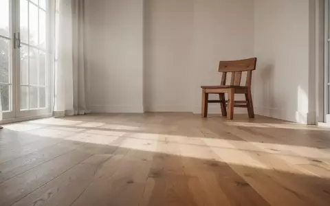 Ein heller, minimalistischer Wohnraum mit einem einzelnen Stuhl auf einem Holzboden in natürlichem Tageslicht. - Foto: über boerse-global.de