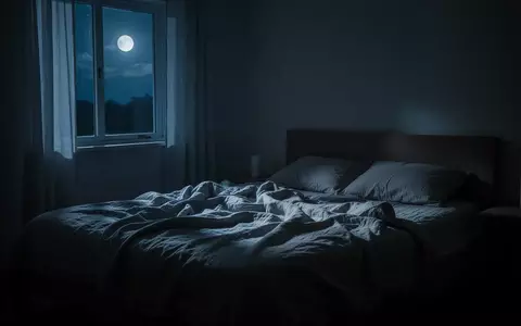 Ein ruhig beleuchtetes Schlafzimmer bei Nacht mit sanftem Mondlicht, das durch ein Fenster auf ein ungemachtes Bett fällt. - Foto: über boerse-global.de