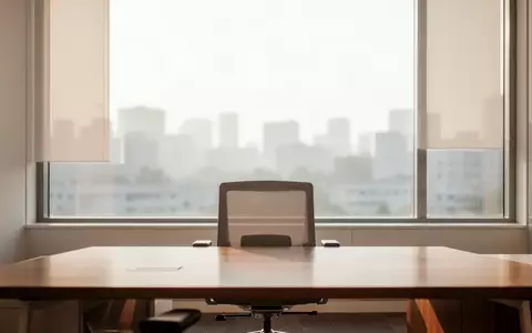 Ein minimalistischer Arbeitsbereich mit einem leeren Schreibtisch und einem Fenster mit Blick auf eine städtische Skyline. - Foto: über boerse-global.de