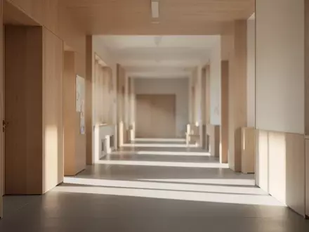 Ein ruhiger, sonnendurchfluteter Flur in einer modernen Bildungseinrichtung mit minimalistischen Holzoberflächen. - Foto: über boerse-global.de