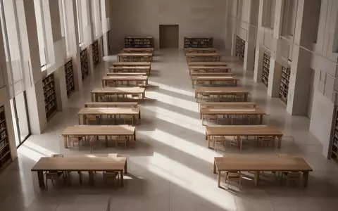 Ein minimalistischer, heller Bibliotheksraum mit leeren Holztischen und geometrischen Schattenwürfen auf dem Boden. - Foto: über boerse-global.de
