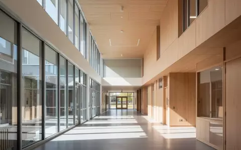 Ein heller, moderner Flur in einem Schulgebäude mit minimalistischer Architektur und natürlichem Tageslicht. - Foto: über boerse-global.de