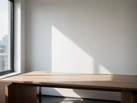 Ein minimalistischer, leerer Büroarbeitsplatz mit natürlichem Lichteinfall und klaren architektonischen Linien. - Foto: über boerse-global.de