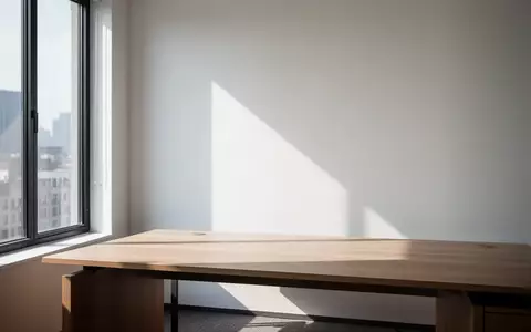 Ein minimalistischer, leerer Büroarbeitsplatz mit natürlichem Lichteinfall und klaren architektonischen Linien. - Foto: über boerse-global.de