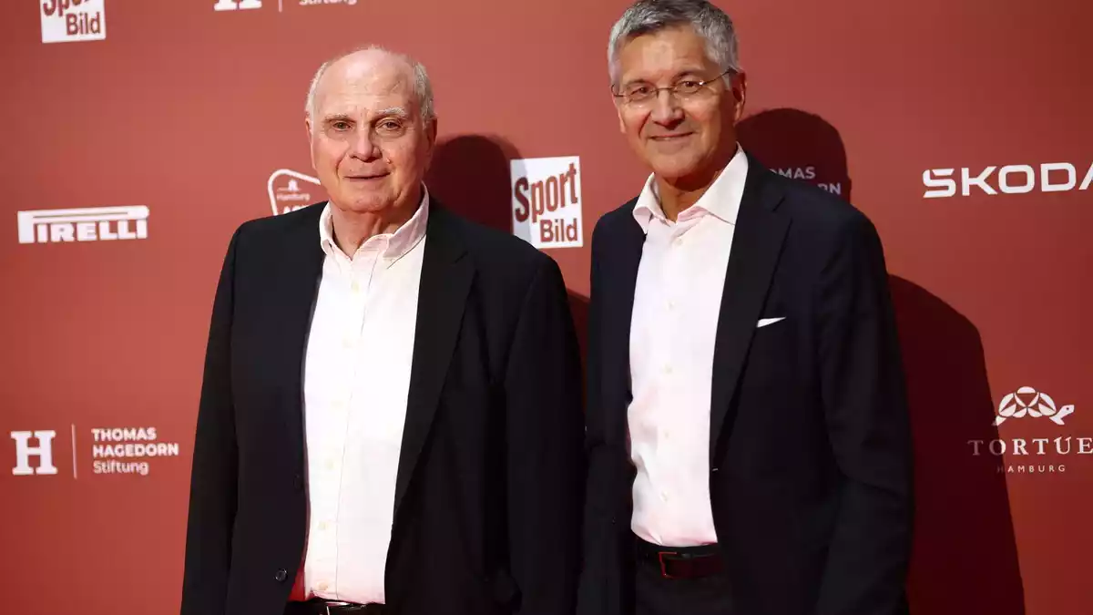 Die Bayern-Granden Hoeneß und Hainer erwarten den FC Bayern wieder an der Tabellenspitze. (Archivbild) - Bild: Christian Charisius/dpa