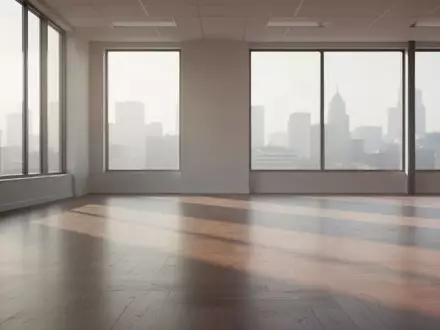Ein minimalistischer, leerer Büroraum mit sanftem Lichteinfall und langen Schatten auf einem polierten Holzboden. - Foto: über boerse-global.de