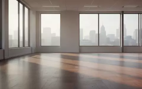 Ein minimalistischer, leerer Büroraum mit sanftem Lichteinfall und langen Schatten auf einem polierten Holzboden. - Foto: über boerse-global.de