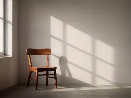 Ein ruhiger, sonnendurchfluteter Raum mit einem leeren Holzstuhl vor einem Fenster, der eine Atmosphäre von Stille und innerer Balance vermittelt. - Foto: über boerse-global.de