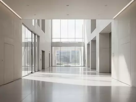 Ein minimalistischer, lichtdurchfluteter Flur in einem modernen Verwaltungsgebäude mit klaren architektonischen Linien. - Foto: über boerse-global.de