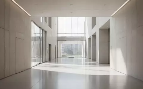 Ein minimalistischer, lichtdurchfluteter Flur in einem modernen Verwaltungsgebäude mit klaren architektonischen Linien. - Foto: über boerse-global.de