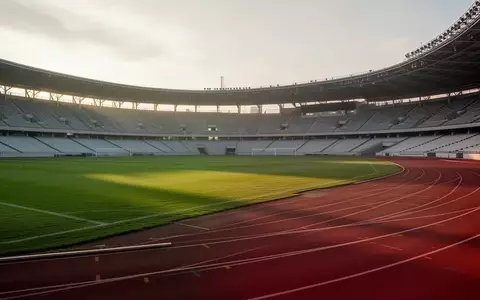 Ein leeres, professionelles Sportstadion mit einer grünen Rasenfläche und einer Laufbahn bei natürlichem Morgenlicht. - Foto: über boerse-global.de