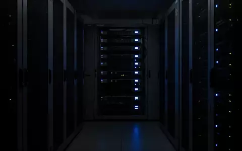 Dunkler, minimalistischer Serverraum mit schwach leuchtenden blauen Status-LEDs an Hardware-Racks. - Foto: über boerse-global.de