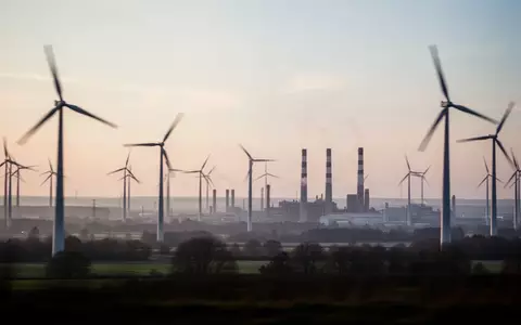 Industrielandschaft mit Windkraftanlagen und Fabrikschornsteinen bei Morgendämmerung in Deutschland. - Foto: über boerse-global.de