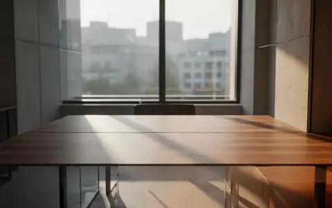 Minimalistischer, leerer Arbeitsbereich mit natürlichem Licht, der auf eine ruhige städtische Umgebung blickt. - Foto: über boerse-global.de