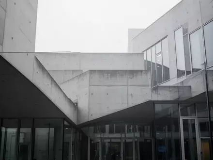 Moderne Fassade eines Verwaltungsgebäudes aus Beton und Glas bei bewölktem Himmel. - Foto: über boerse-global.de