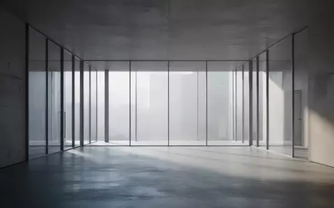 Ein minimalistischer, moderner Innenraum mit klaren Linien und hellem, diffusem Tageslicht, das durch große Fenster fällt. - Foto: über boerse-global.de