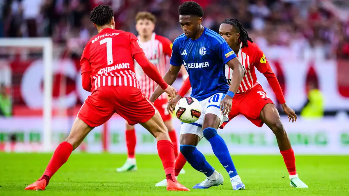 Umzingelt: Schalkes Junior Adamu (M.) gegen Ex-Club Freiburg. - Bild: Tom Weller/dpa