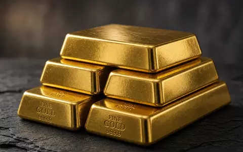 Mehrere glänzende Goldbarren auf einer dunklen Schieferplatte bei natürlichem Licht. - Foto: über boerse-global.de