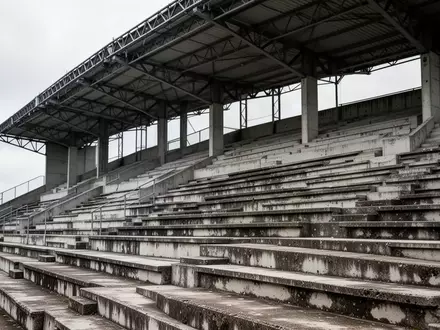 Leere, graue Betontribünen eines Stadions mit einer symmetrischen Anordnung von Sitzreihen und Stahlträgern. - Foto: über boerse-global.de
