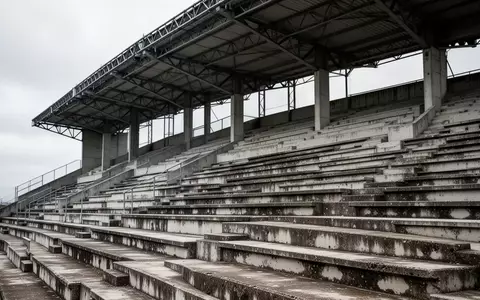 Leere, graue Betontribünen eines Stadions mit einer symmetrischen Anordnung von Sitzreihen und Stahlträgern. - Foto: über boerse-global.de