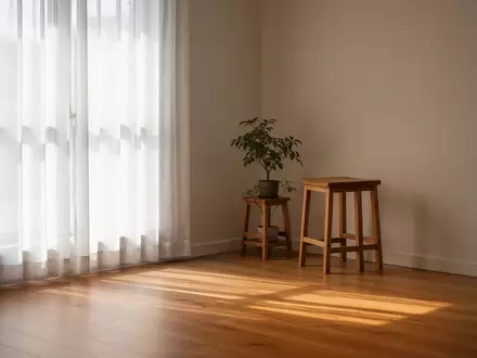 Ein ruhiger, minimalistischer Raum mit natürlichem Licht, einem schlichten Holzhocker und einer kleinen Zimmerpflanze. - Foto: über boerse-global.de