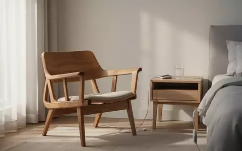 Ein minimalistisch eingerichtetes Wohnzimmer mit einem leeren Sessel und einem Nachttisch in natürlichem Tageslicht. - Foto: über boerse-global.de