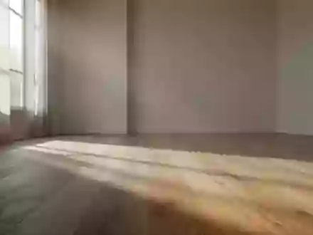 Ein ruhiger, minimalistischer Raum mit weichem Tageslicht und sanften Schatten auf einem Holzboden. - Foto: über boerse-global.de