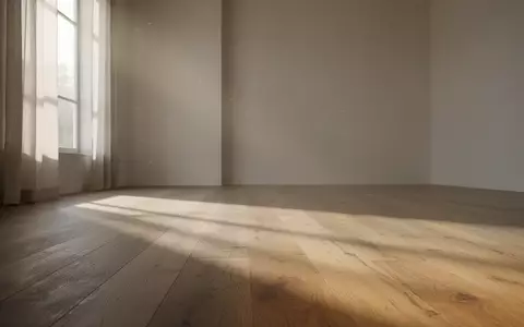 Ein ruhiger, minimalistischer Raum mit weichem Tageslicht und sanften Schatten auf einem Holzboden. - Foto: über boerse-global.de