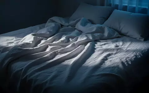 Ein ungemachtes Bett mit zerknitterten weißen Leinentüchern in einem ruhig beleuchteten Schlafzimmer bei Morgendämmerung. - Foto: über boerse-global.de