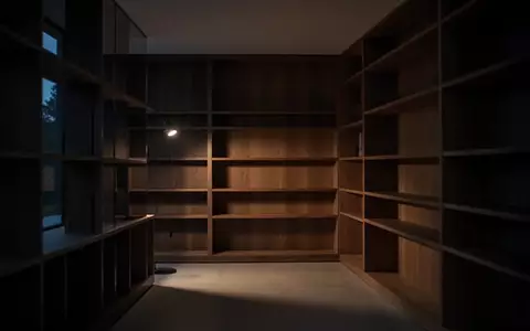 Ein schlichtes, modern eingerichtetes Zimmer in der Abenddämmerung mit weichem Licht und leeren Regalen. - Foto: über boerse-global.de