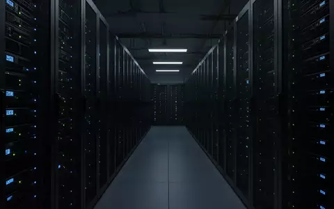Dunkler Serverraum mit unbeleuchteten Serverschränken in einer langen Reihe. - Foto: über boerse-global.de